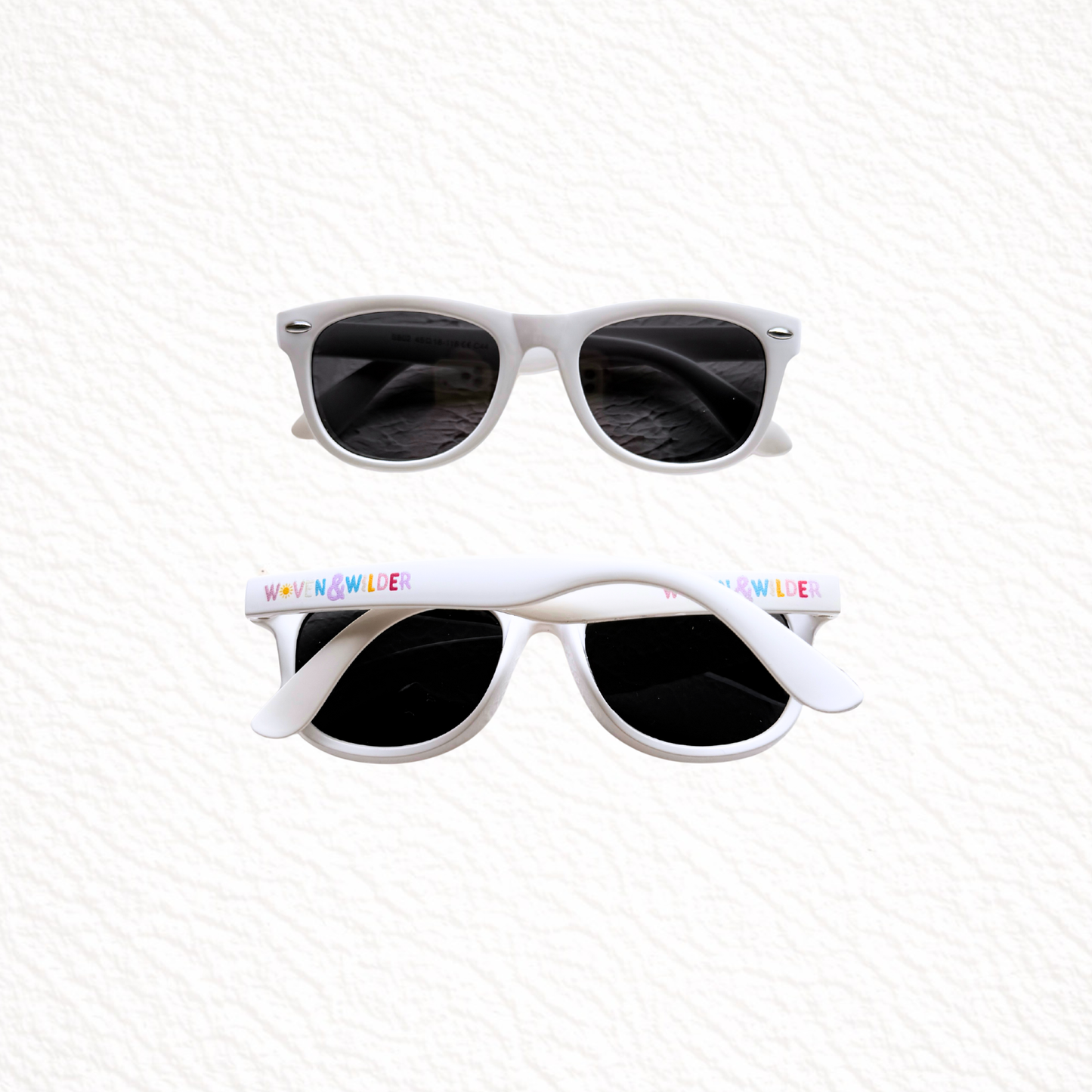 White sunglasses with colorful text on the frame against a white background