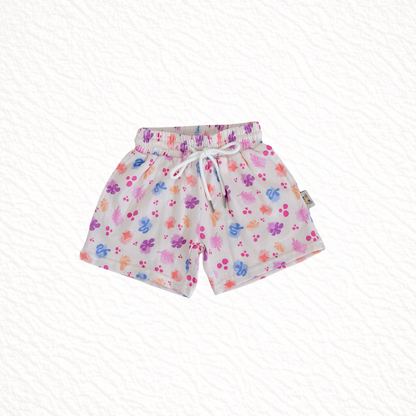 Children's shorts with colorful paw print pattern on a white background