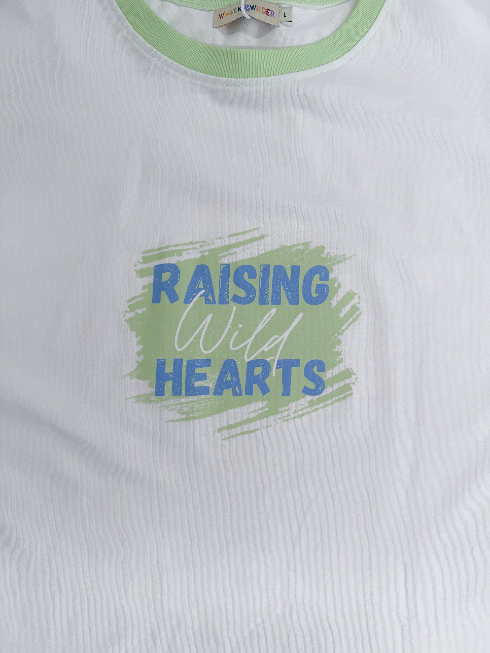 White t-shirt with 'Raising Wild Hearts' text and green border on a white background