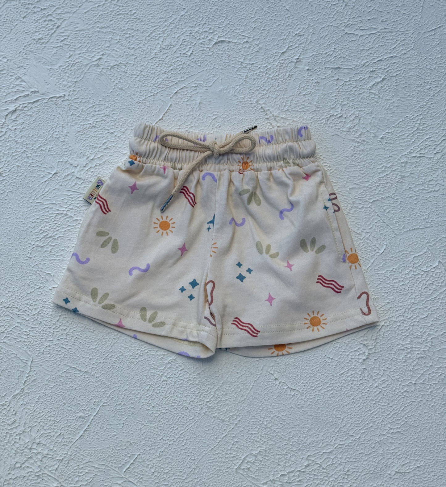 Children's shorts with colorful patterns on a light blue background