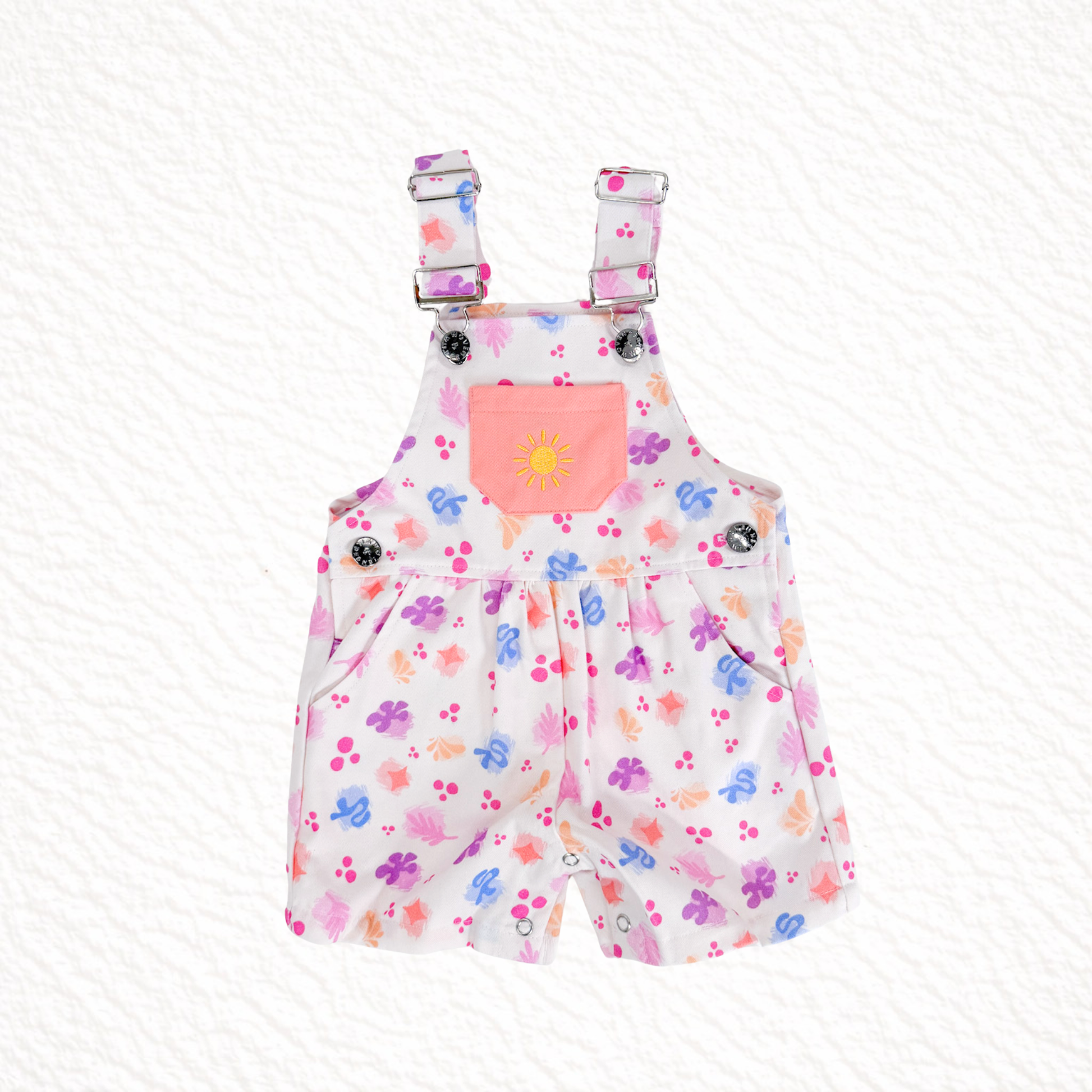 Children's floral overalls with a pink pocket on a white background