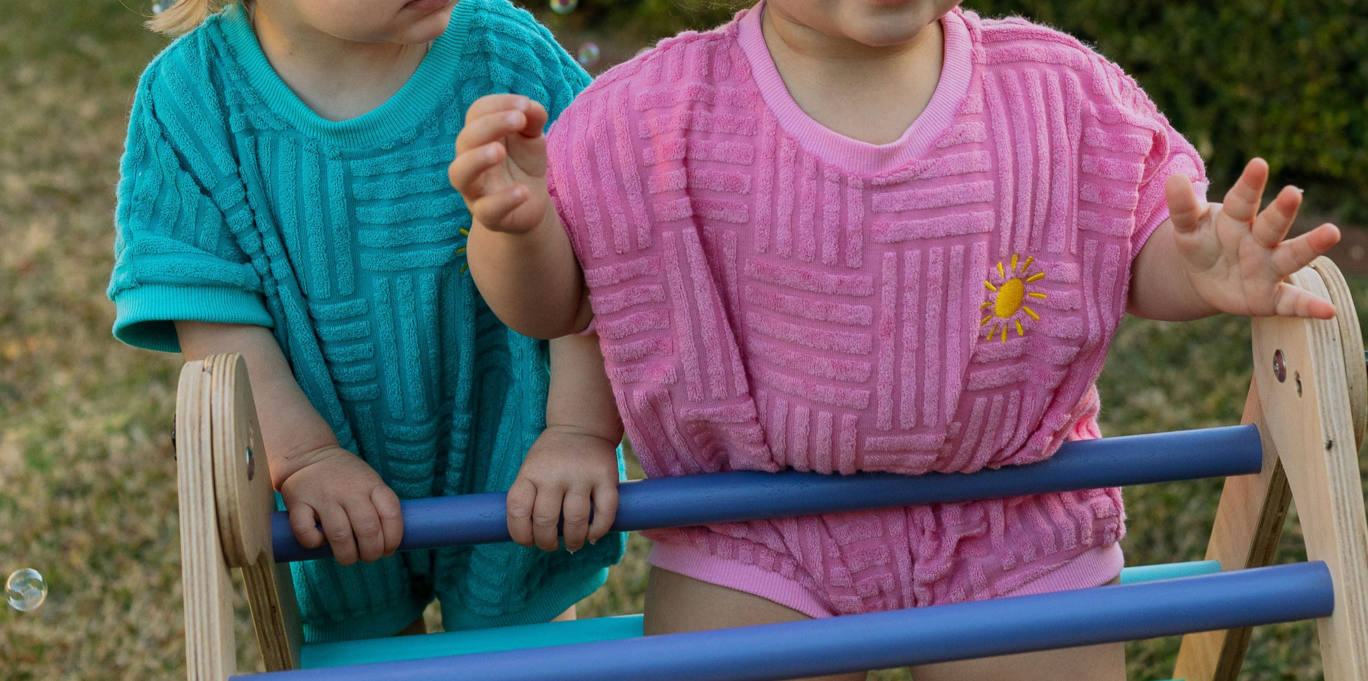 Two children playing on a playground structure with a blurred background