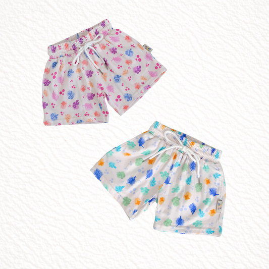 Two pairs of children's shorts with colorful patterns on a white background