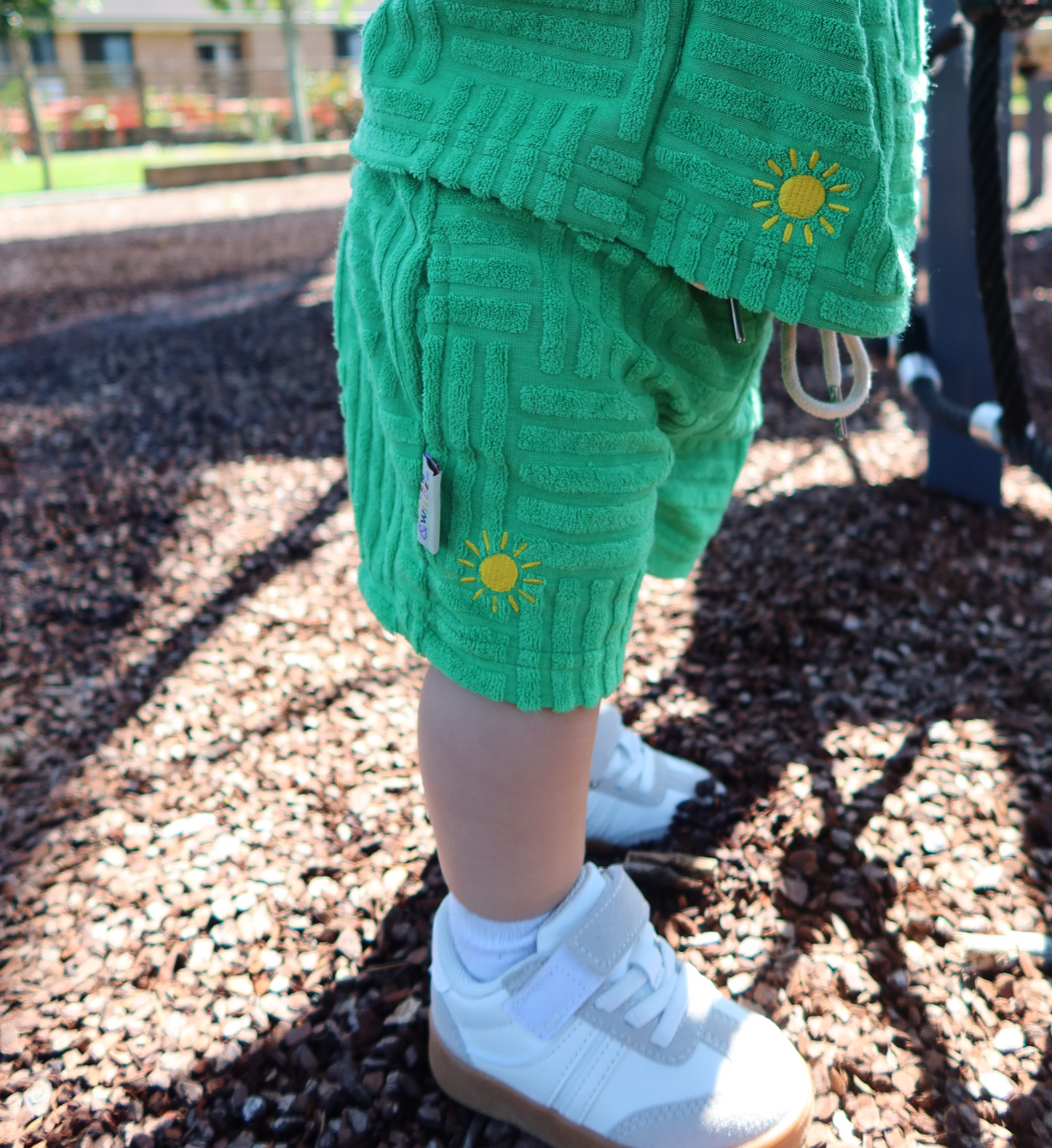 Green textured outfit with sun design on a playground