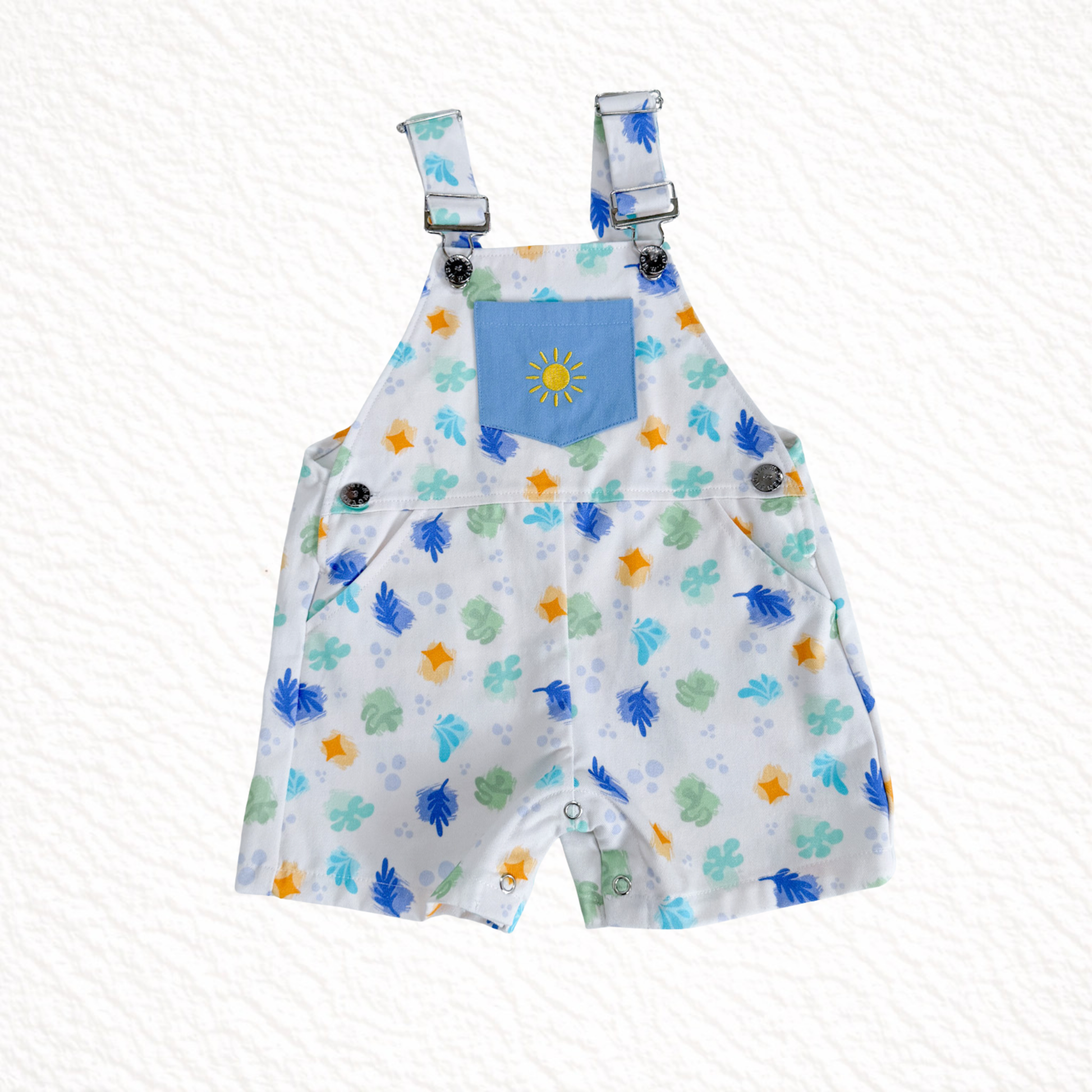 Children's overalls with colorful animal print and blue pocket on a white background