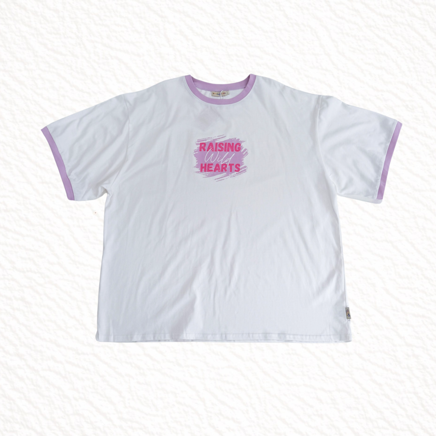 Raising wild hearts in pink text on a white tshirt on a white background