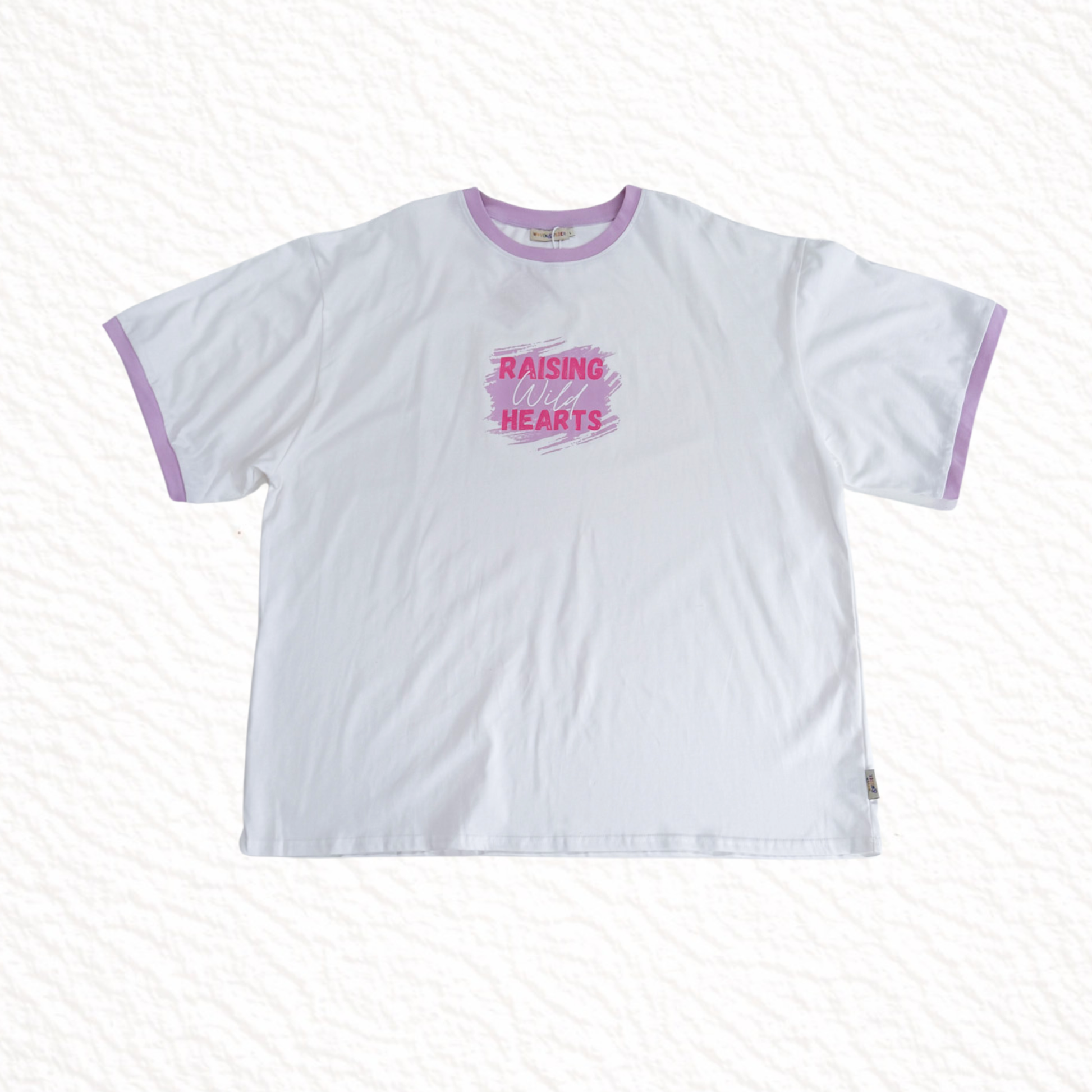 Raising wild hearts in pink text on a white tshirt on a white background