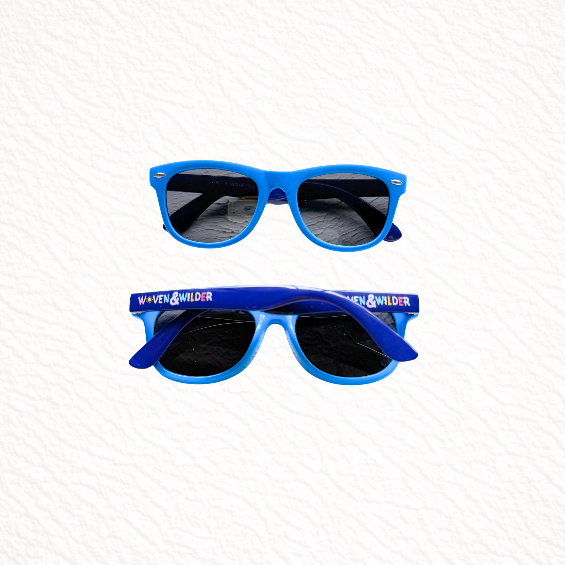 Blue sunglasses with 'Woven & Wilder' branding on a white background