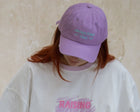 A mother wearing a raising heart tee with her kid wearing an overall with colorful caps against a plain background