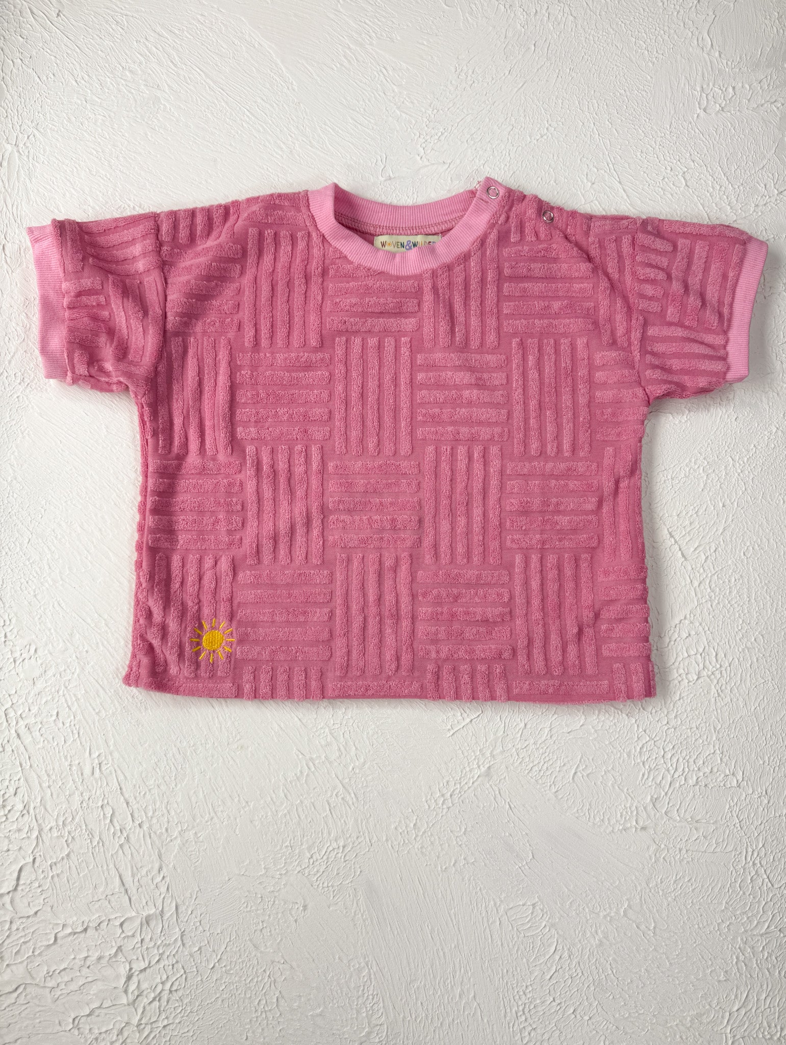 Pink textured t-shirt on a light gray background