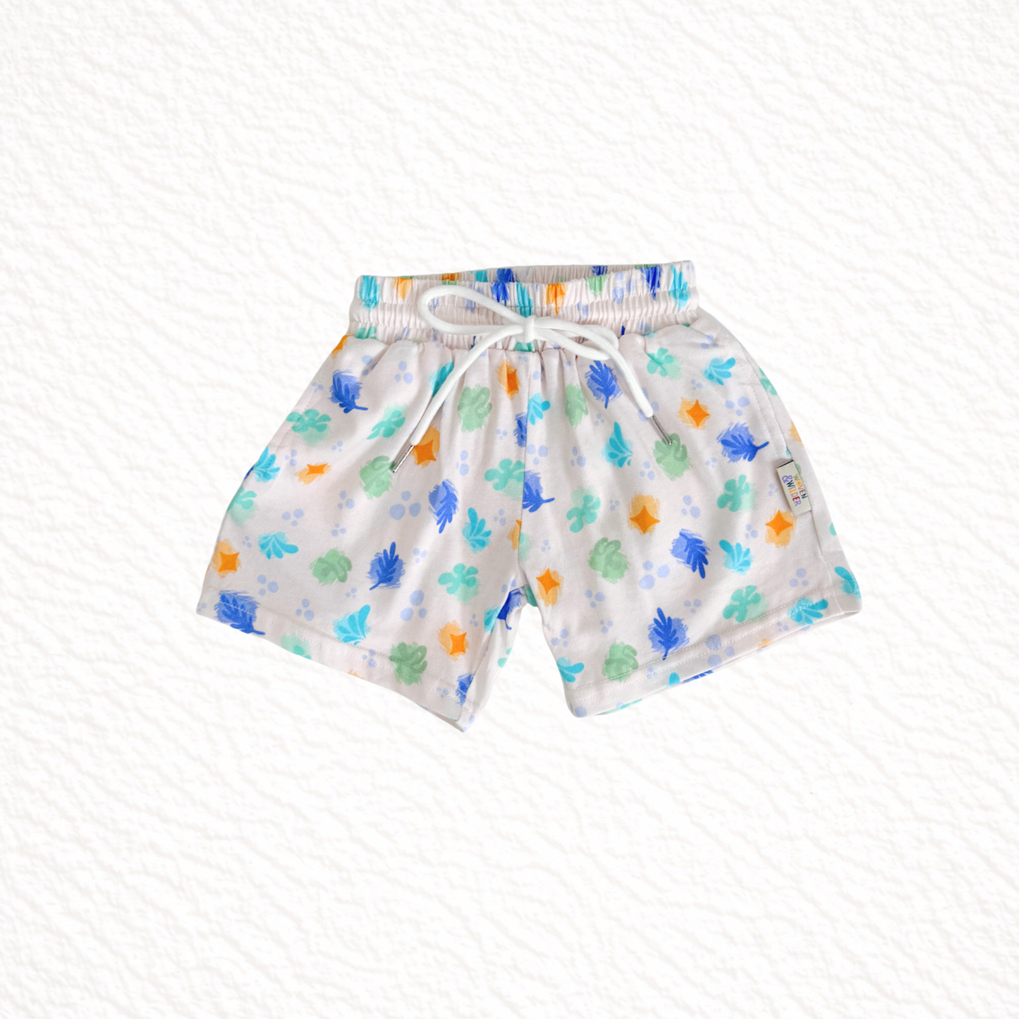 Children's shorts with colorful leaf pattern on a white background