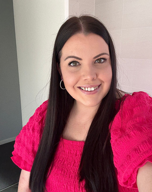 Woven WIlder founder wearing a bright pink top against a neutral background